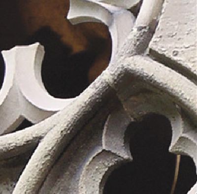 Detailaufnahme eines steinernen Maßwerks mit geschwungenen, gotischen Formen und Durchbrüchen.