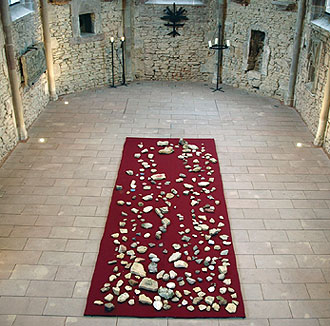 Roter, mit Steinen bedeckter Teppich auf dem Boden der Kapelle.