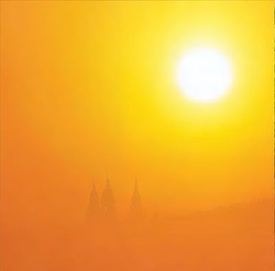 Grelle Sonne, die eine Landschaft mit ihrem Licht gelb-orange überstrahlt.